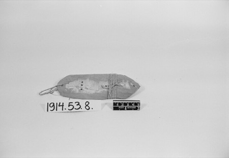A small oblong board pierced with a cluster of holes and wrapped with cord and thread, photographed on a museum scale card: a Cypriot...