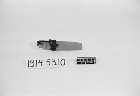 A Cypriot bullroarer in the Pitt Rivers Museum: a smooth flat wooden slat with a cord looped through a hole near one end — shown for the...