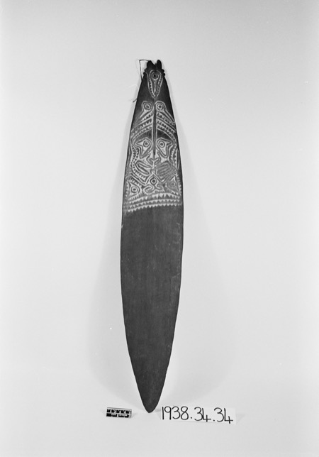 A Gulf mask-lot blade, PRM 1938.34.34: a face carved above the plain lower body.