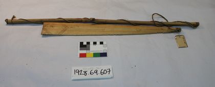 The complete Shiong rig, sibling of the blade above: notched pale blade and long cane handle, still strung with plaited cord (PRM 1928.69.607).