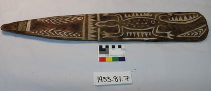 Orokolo bull-roarer with a crocodile carved between white zig-zag borders, bought from James Hooper in 1933 (Pitt Rivers Museum 1933.81.7).