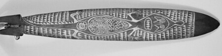 Carved Orokolo bull-roarer with a crocodile motif and incised borders (Pitt Rivers Museum 1933.81.6).