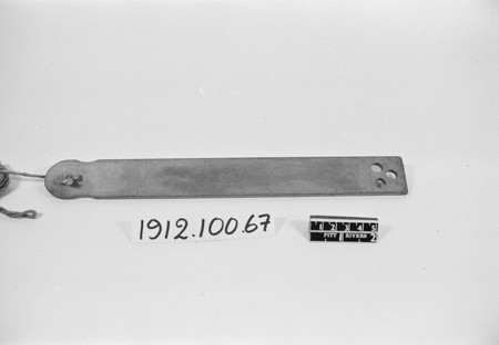 The second Chichester whizzing blade, with three small holes at its square end and cord at the rounded end.