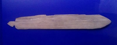 A medieval wooden whirring blade from Novgorod, 14th century: a plain tapered board narrowing to a carved cord tang at one end. No photograph...