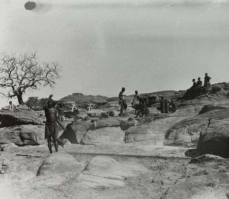 A man spins a rhombe at the approach of women, who must keep clear of anything involving masks — Marcel Griaule field photograph, Sanga,...